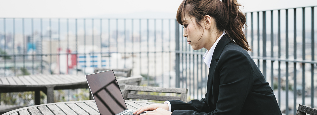 일본 교토의 건물 외부에서 노트북으로 일하는 여성